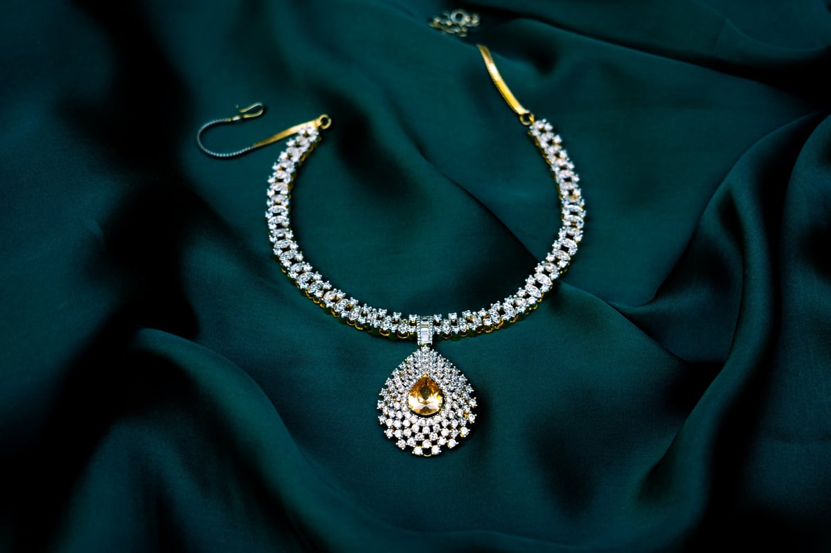 A luxurious white gemstone necklace on a green cloth surface