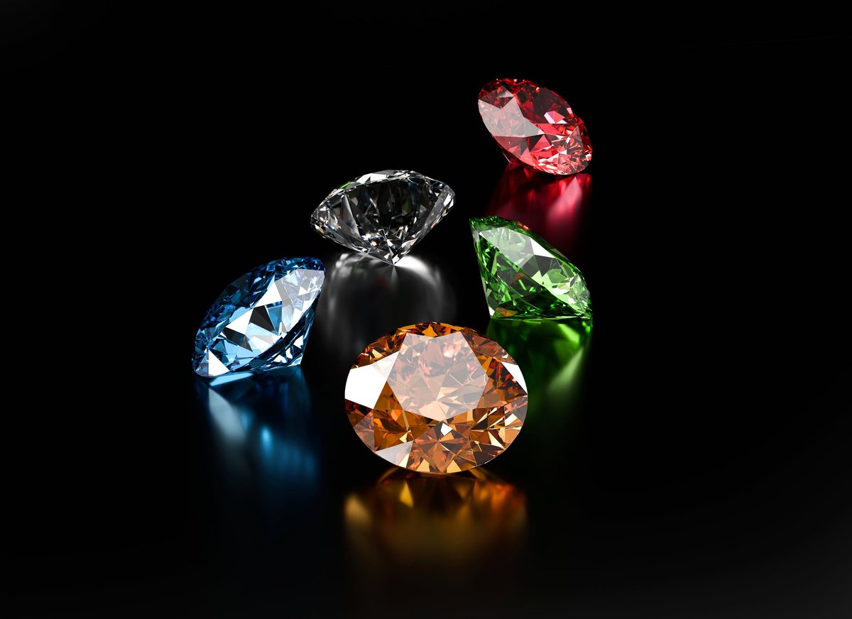 Colorful gemstones placed on a glossy reflective background